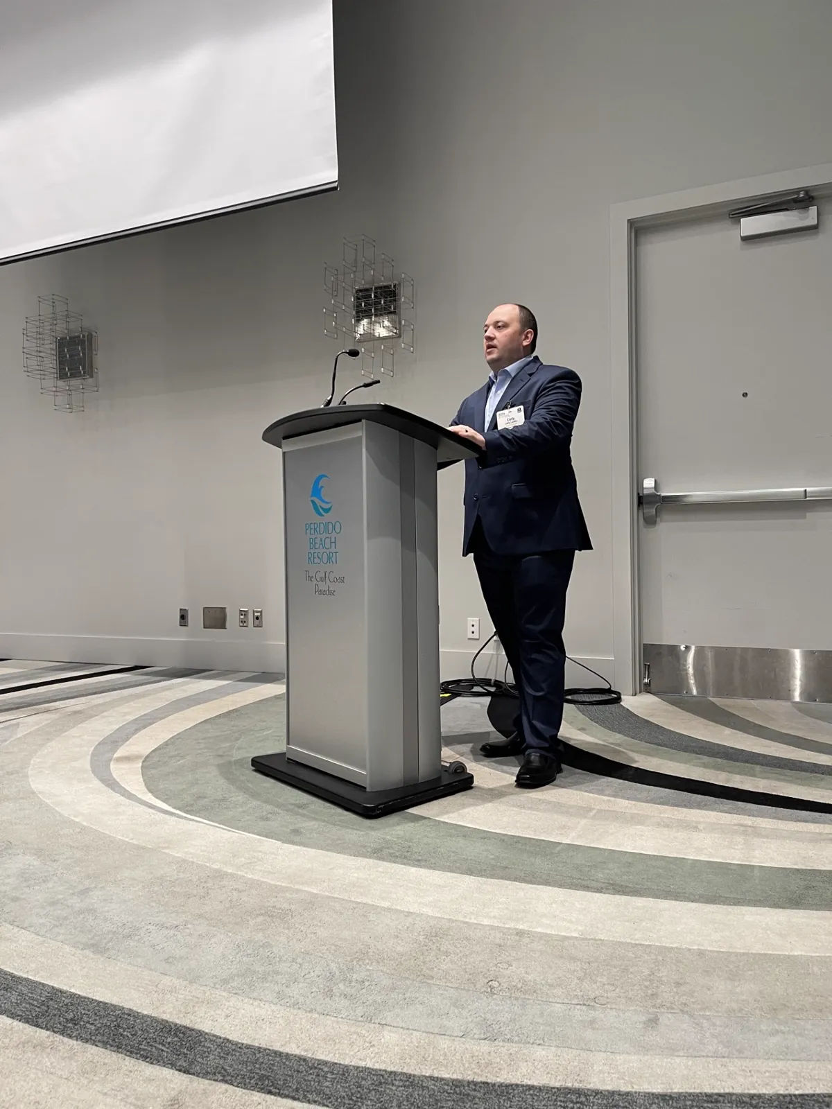 Cody Landry speaking at a conference podium
